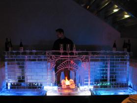 12 ft fireplace ice bar with theatrical flickering flame lighting in back of ice logs.
