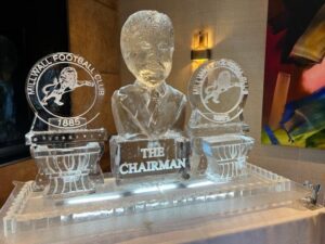 Bust of The Chairman and servers with logos 